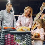Why More Families Are Choosing Intentional Spending Over Impulse Buying A family shopping together in a grocery store, with a child holding food items