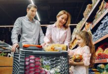 A family shopping together in a grocery store, with a child holding food items