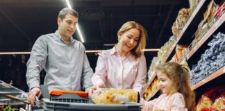 A family shopping together in a grocery store, with a child holding food items