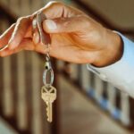 Why Tiny Home Rentals Are Gaining Popularity as Housing Costs Rise A hand holding a key on a keychain