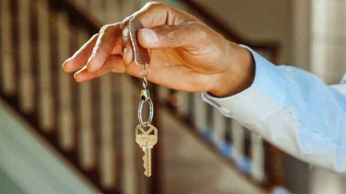 A hand holding a key on a keychain