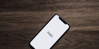 A smartphone displaying the word 'Hello' on a wooden table