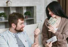 A couple sitting on a couch, discussing money and holding cash and a receipt