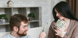 A couple sitting on a couch, discussing money and holding cash and a receipt