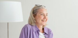 Smiling woman in a purple shirt sitting indoors