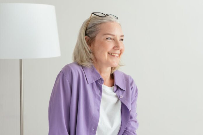 pexels-mikhail-nilov-8307321.jpg Smiling woman in a purple shirt sitting indoors