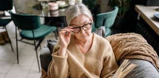 Senior woman reading a book while sitting on a couch