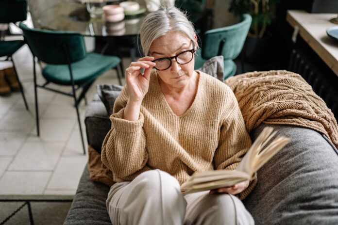 pexels-yankrukov-6817647.jpg Senior woman reading a book while sitting on a couch